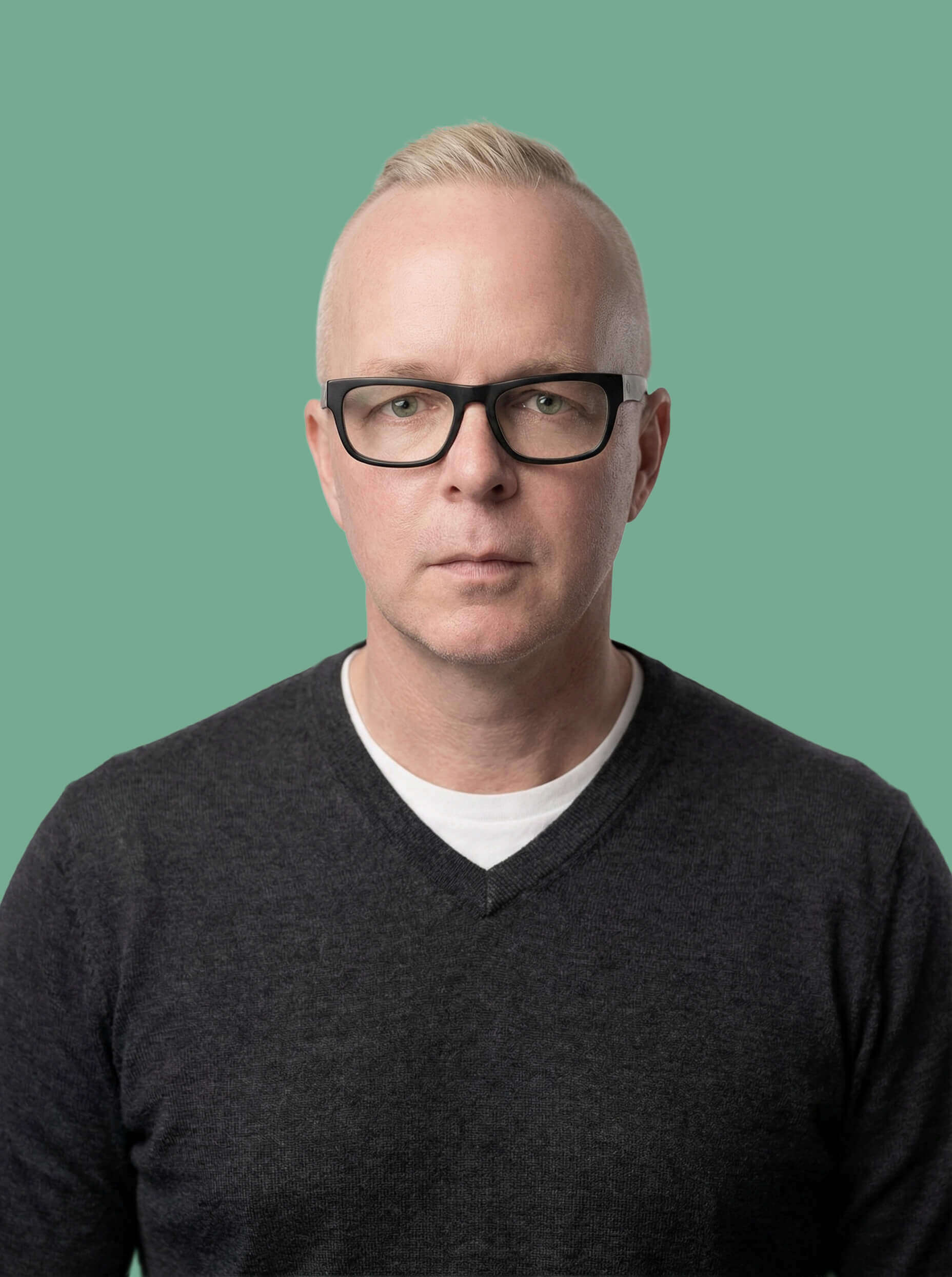 John Manicke profile picture wearing a dark grey sweater with a sage green background